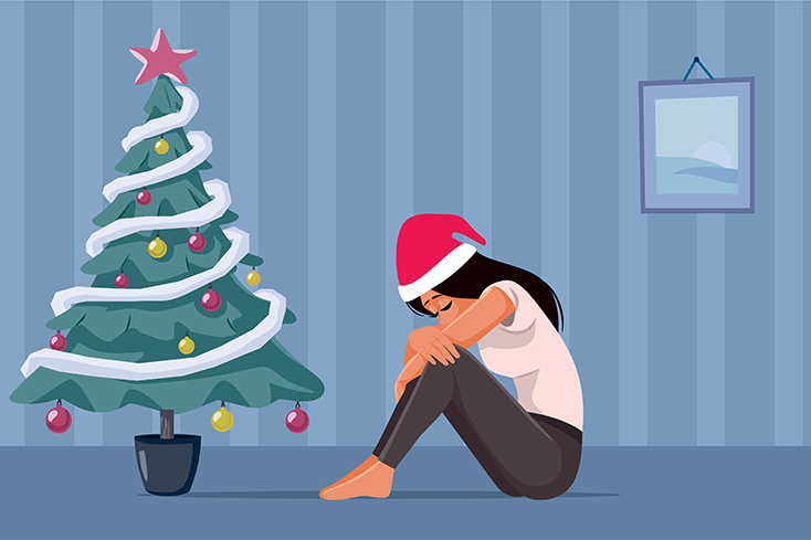 Woman sad next to a Christmas tree