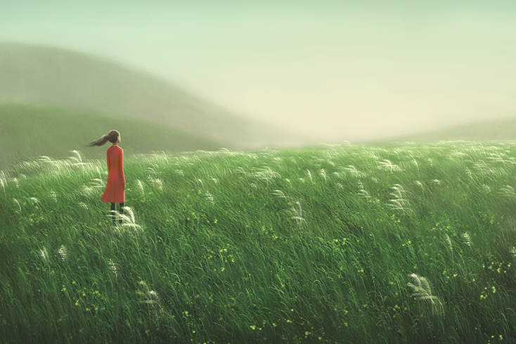 Woman standing in windy field