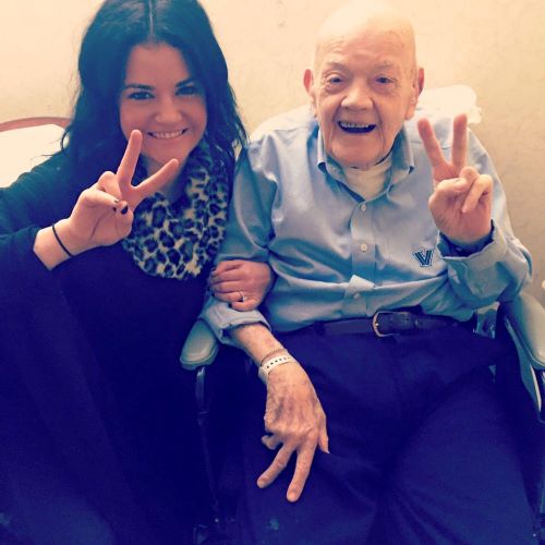 woman and elderly man making peace sign gesture